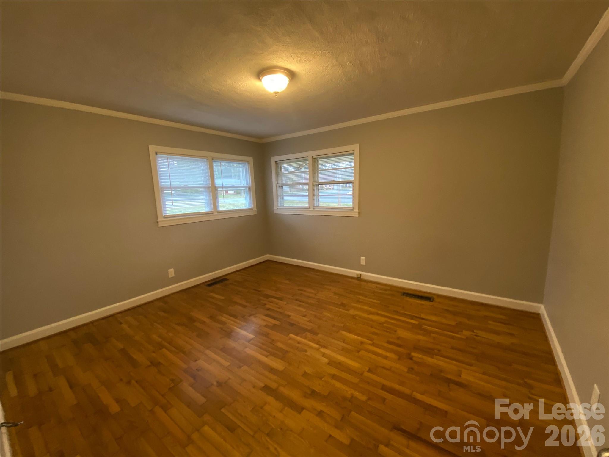 508 Dunham Road Gastonia, NC 28054 - Photo 9 of 16 an empty room with wooden floor and windows