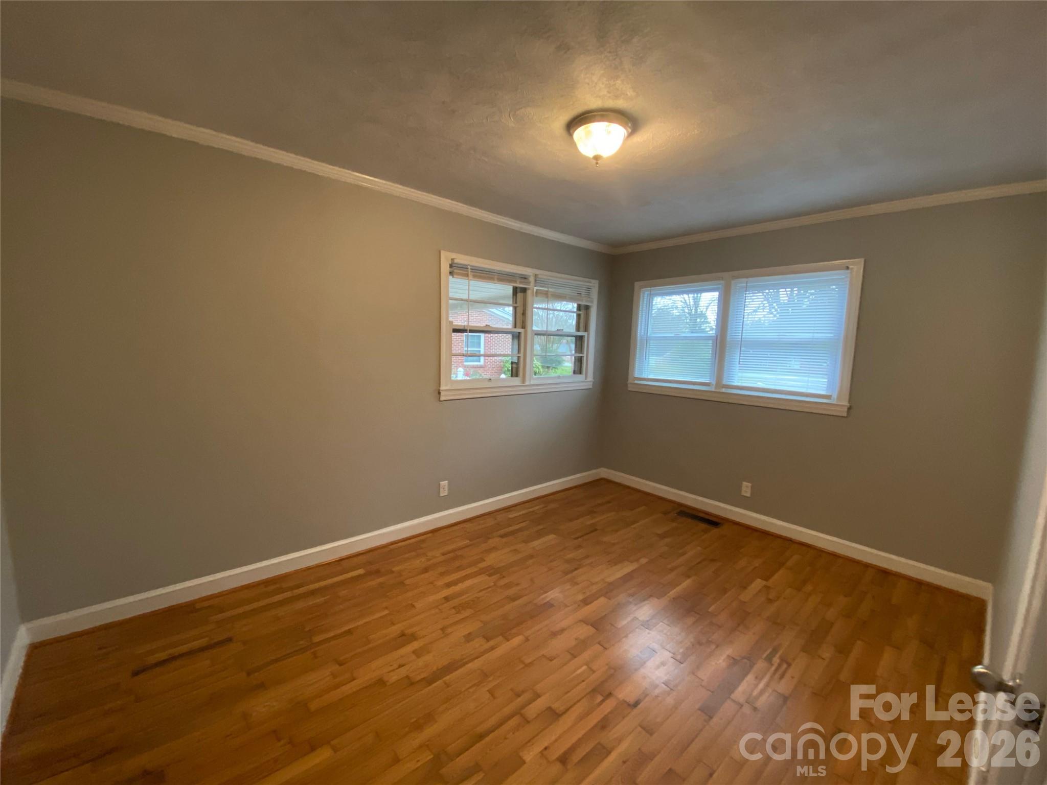 508 Dunham Road Gastonia, NC 28054 - Photo 10 of 16 an empty room with wooden floor and windows