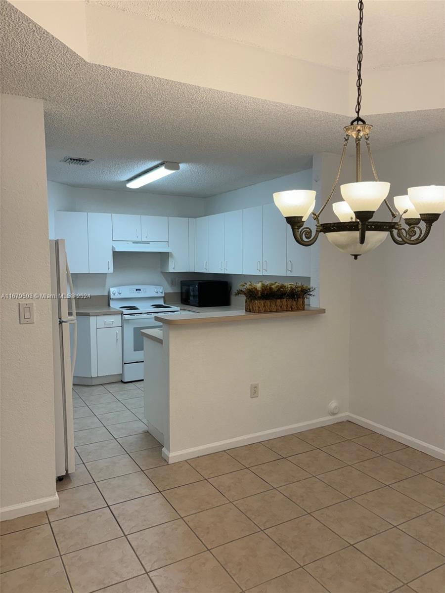 Three Lakes Miami, FL 33186 - Photo 8 of 34 a kitchen with a cabinets and chandelier