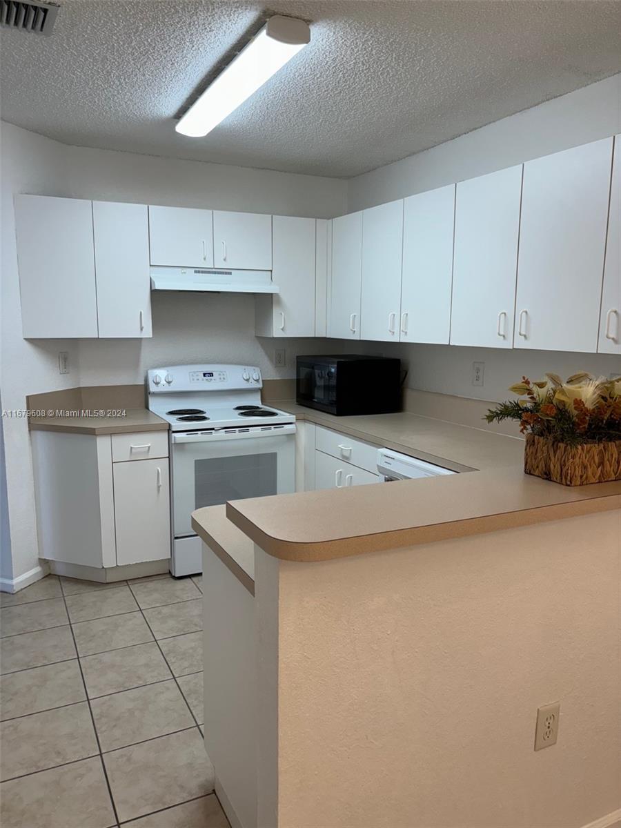 Three Lakes Miami, FL 33186 - Photo 9 of 34 a kitchen with cabinets and white appliances