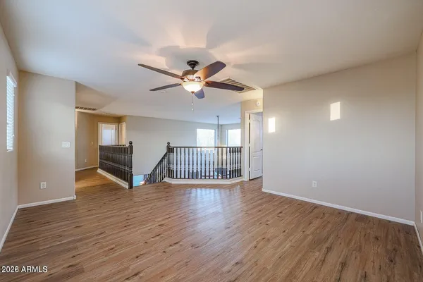 a view of an empty room with window and wooden floor