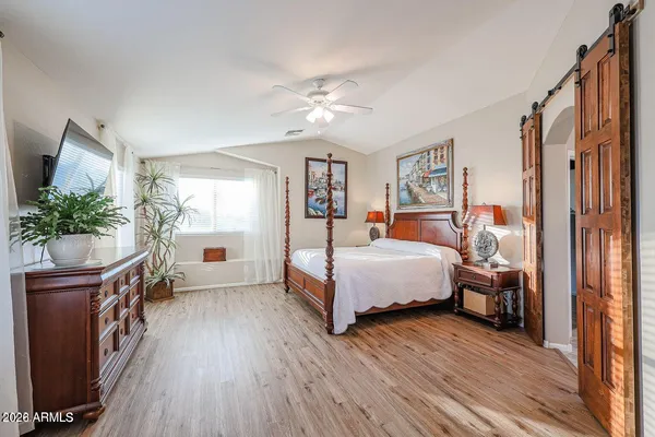 a bedroom with a bed flat screen tv and a window