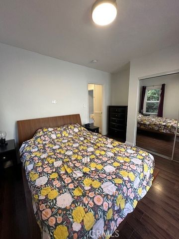 a bedroom with a bed and dresser with mirror