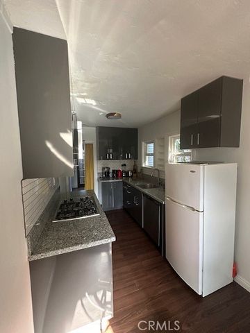 a kitchen with kitchen island granite countertop stainless steel appliances and wooden cabinets