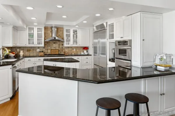 a kitchen with stainless steel appliances granite countertop a sink and a refrigerator