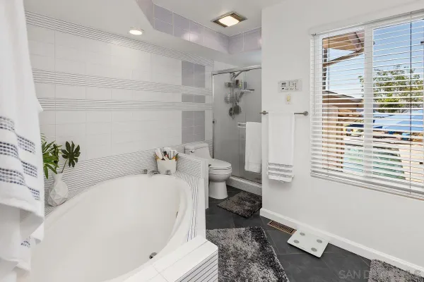a white toilet sitting next to a bathroom sink and a tub