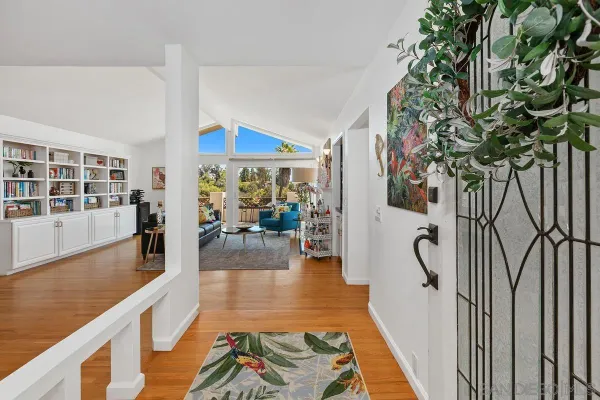 a hallway with dining area and chandelier