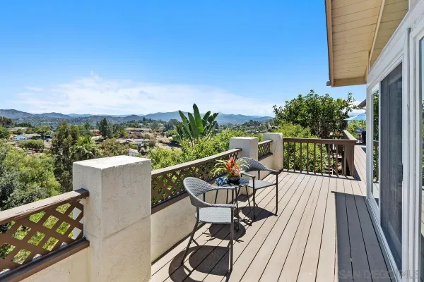 a roof deck with table and chairs and potted plants