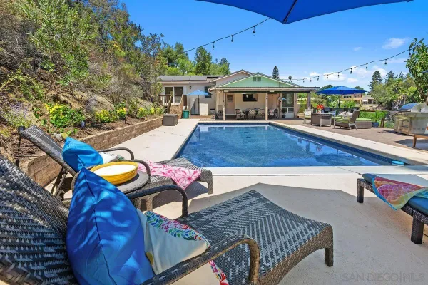 a view of a swimming pool with lounge chairs in patio