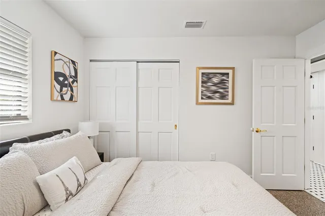 a bedroom with a bed couch and a window