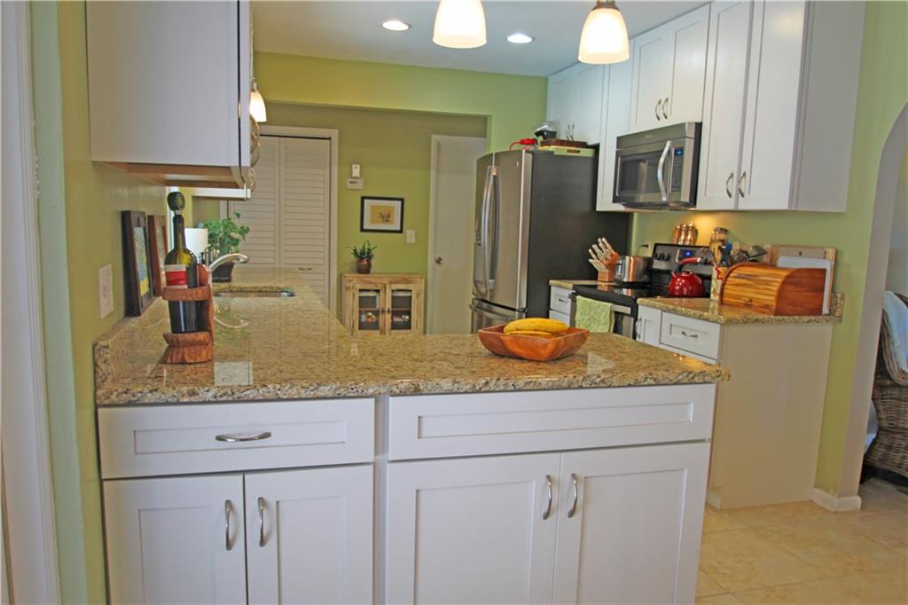 783 Northwest Spruce Ridge Drive Stuart, FL 34994 - Photo 8 of 29 a kitchen with stainless steel appliances granite countertop a sink and a refrigerator