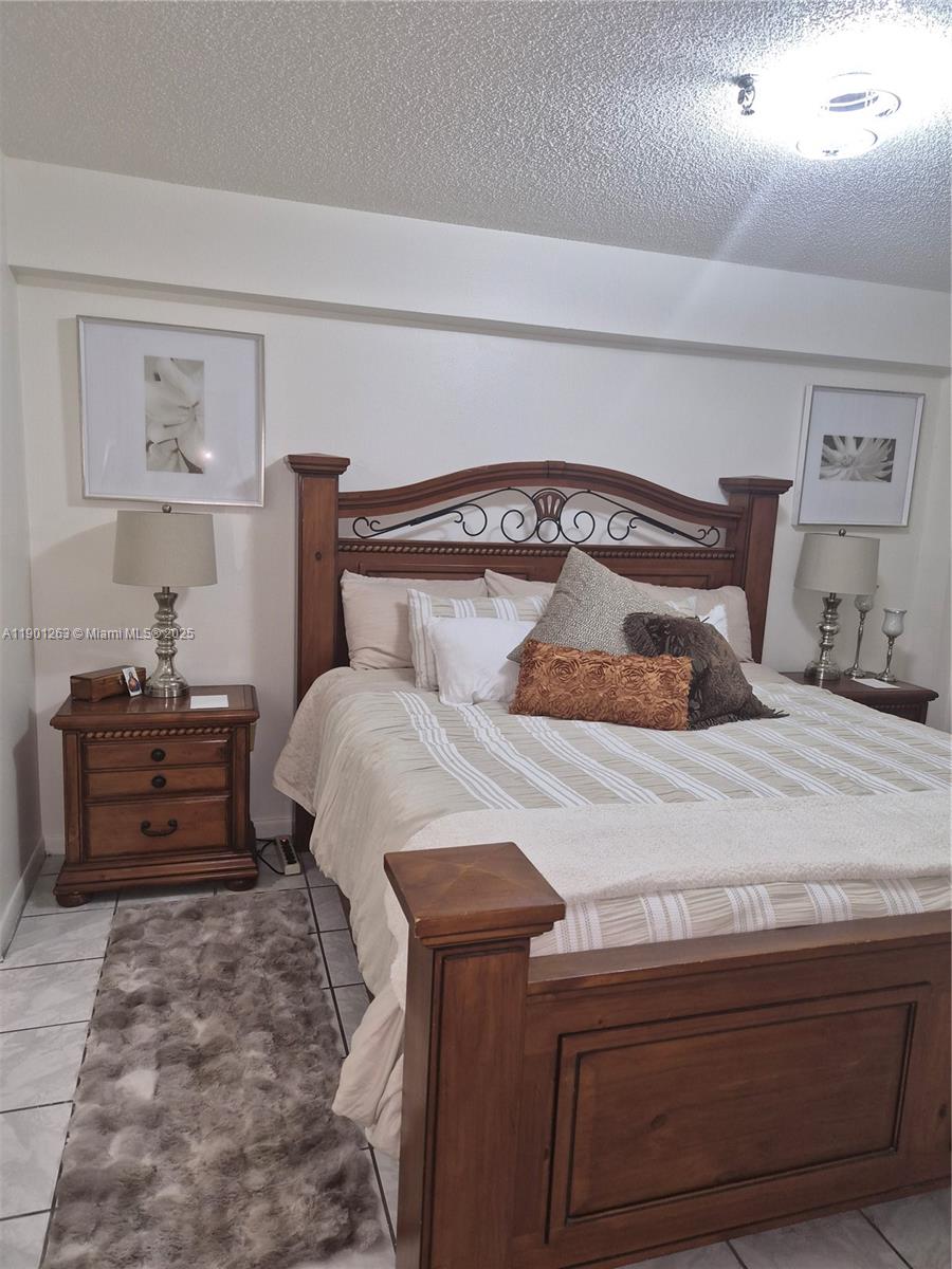 201 180th Drive, Unit 411 Sunny Isles Beach, FL 33160 - Photo 16 of 53 a bedroom with a bed and a window