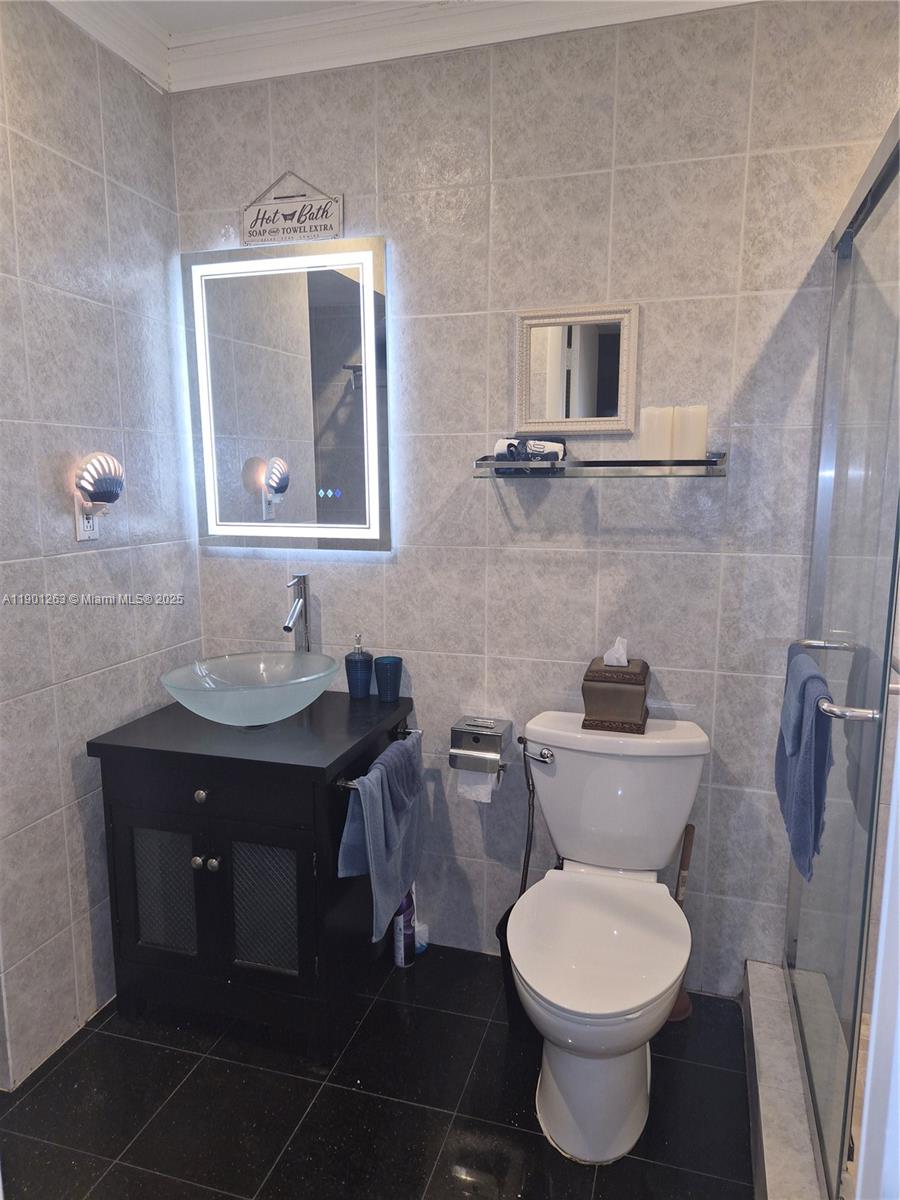 201 180th Drive, Unit 411 Sunny Isles Beach, FL 33160 - Photo 21 of 53 a bathroom with a toilet a sink and mirror