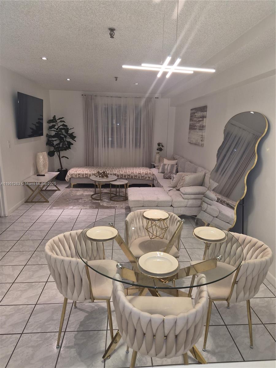 201 180th Drive, Unit 411 Sunny Isles Beach, FL 33160 - Photo 6 of 53 a kitchen with stainless steel appliances granite countertop a dining table and chairs