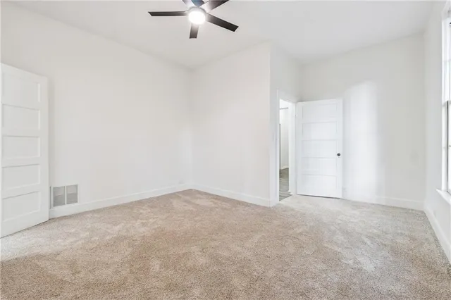 an empty room with chandelier fan