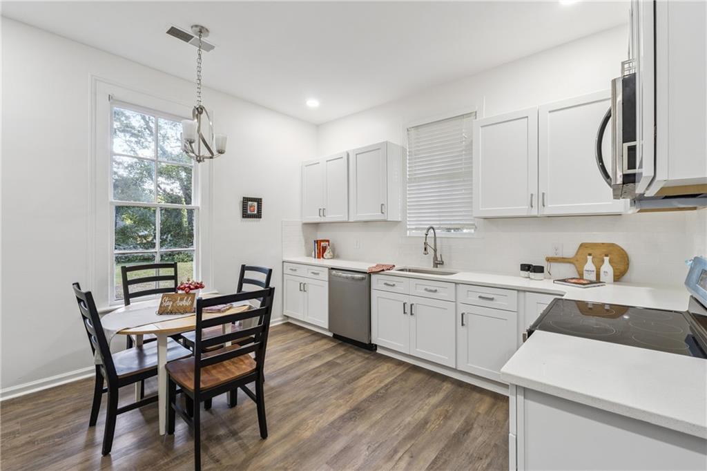 1820 Cassville Road Northwest Cartersville, GA 30121 - Photo 7 of 24 a kitchen with stainless steel appliances granite countertop a table chairs sink and cabinets