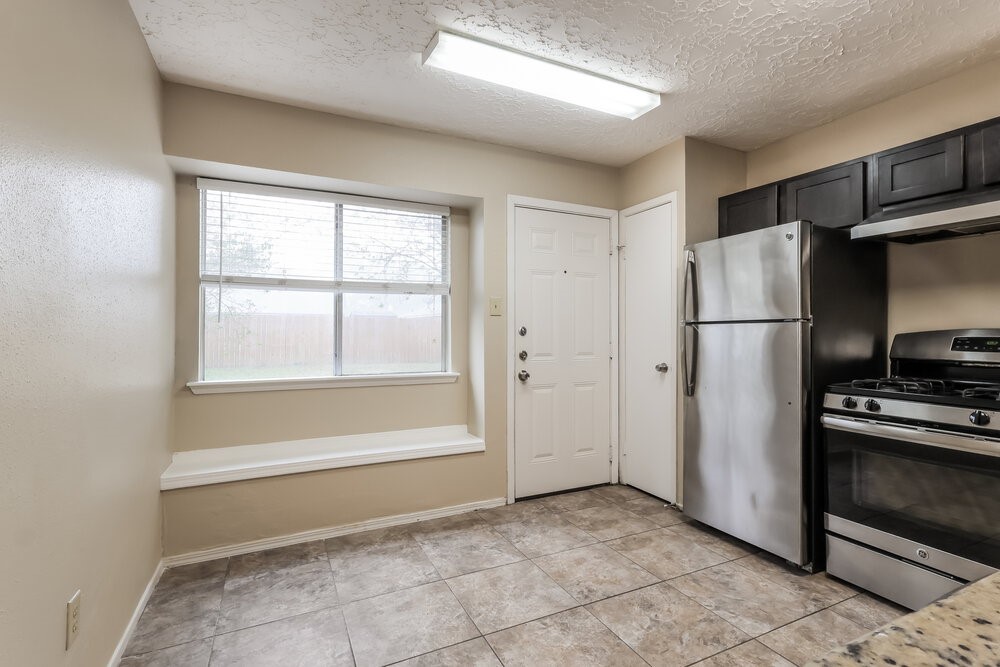 2438 Autumn Springs Lane Spring, TX 77373 - Photo 7 of 16 a view of a kitchen with a refrigerator cabinets and a window