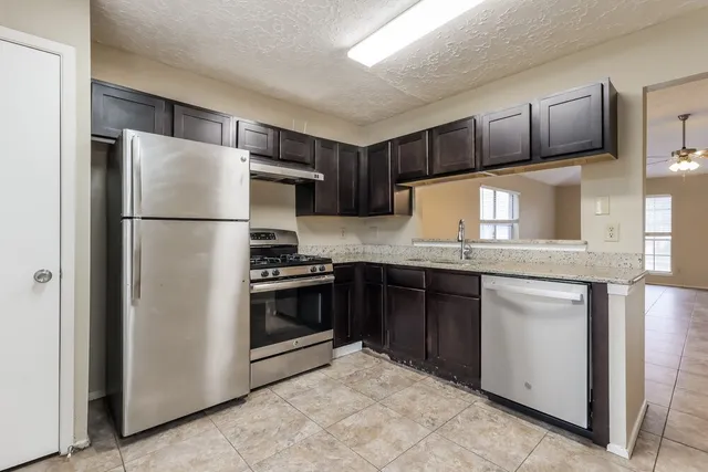 a kitchen with stainless steel appliances granite countertop a refrigerator stove a sink and dishwasher