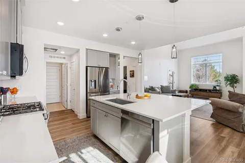 a large kitchen with kitchen island a large counter top space a sink stainless steel appliances and cabinets