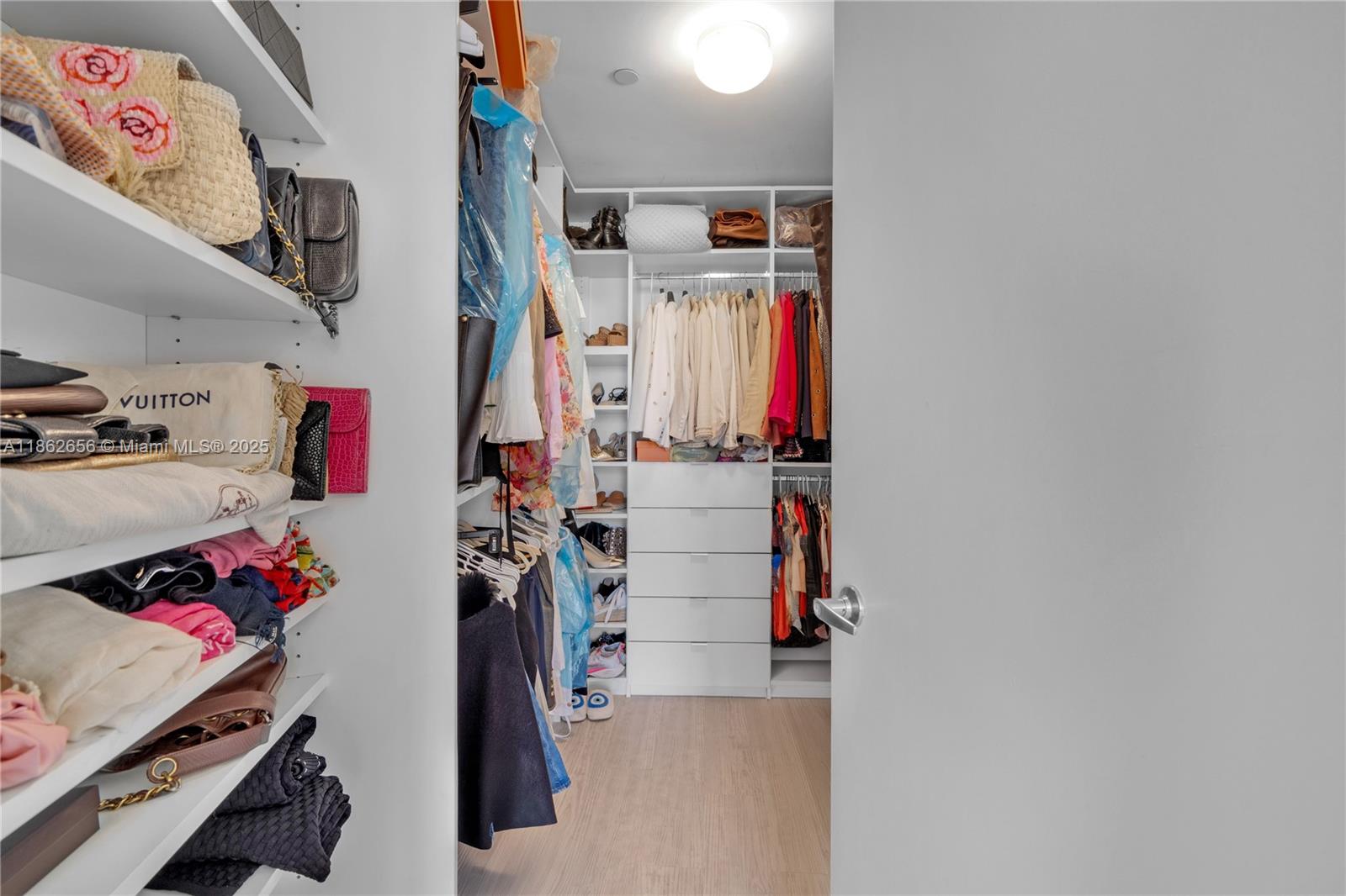 701 Crandon Boulevard, Unit 302 Key Biscayne, FL 33149 - Photo 26 of 46 a view of walk in closet with clothes and shoes