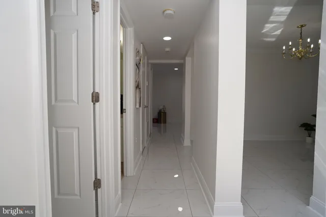 a view of a hallway with closet and a chandelier