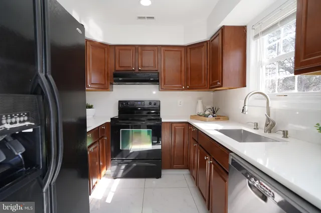 a kitchen with kitchen island granite countertop a sink stove and refrigerator