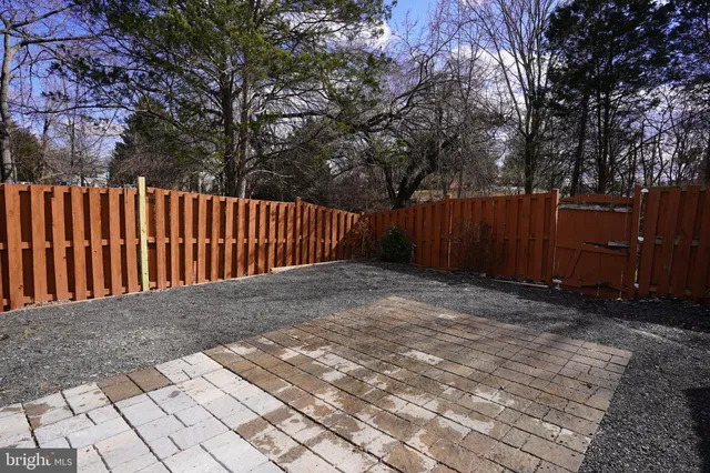 a view of backyard with wooden fence and trees