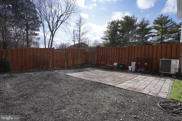 a view of backyard with potted plants and wooden fence