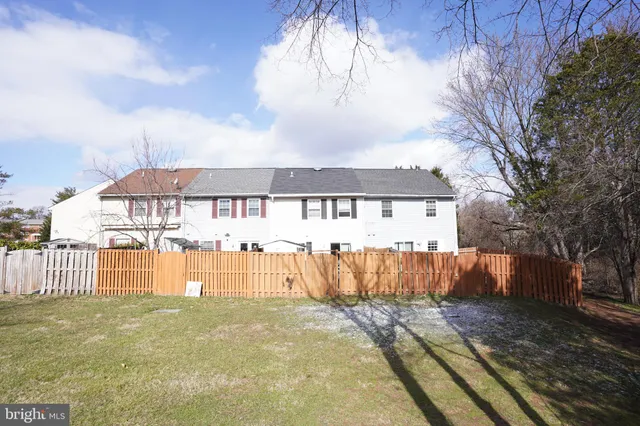 a view of a house with a wooden fence