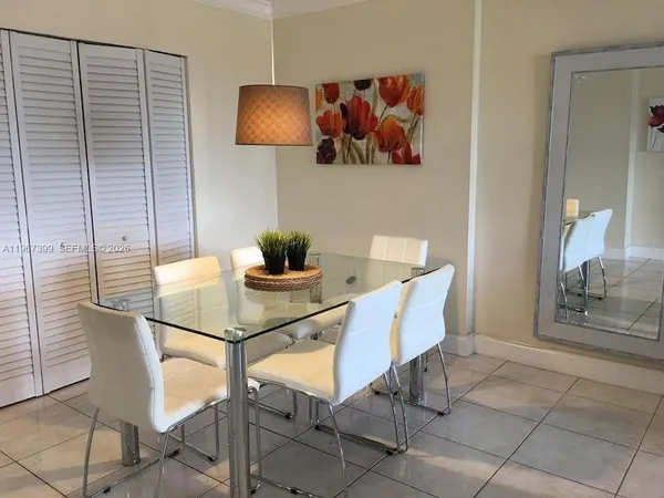 a dining room with furniture and a potted plant