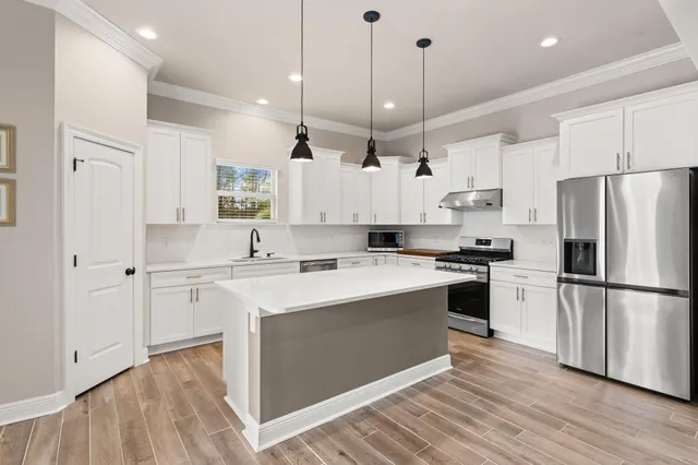 a kitchen with stainless steel appliances a sink stove and cabinets