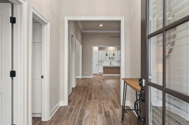 a view of a hallway with wooden floor and staircase