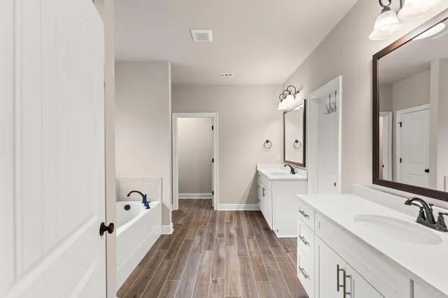 a bathroom with a tub a sink and a window