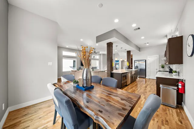 a living room with furniture a flat screen tv and a dining table