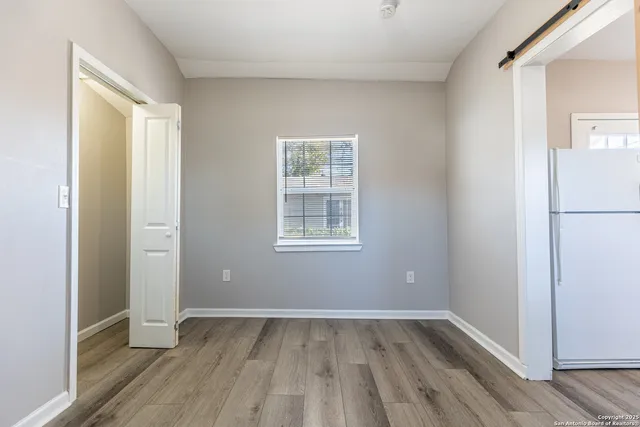 a view of a bathroom with toilet window and wooden floor