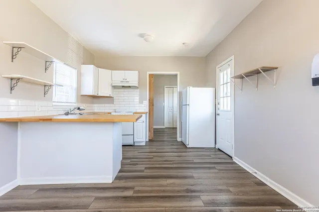 a kitchen with a sink window and cabinets