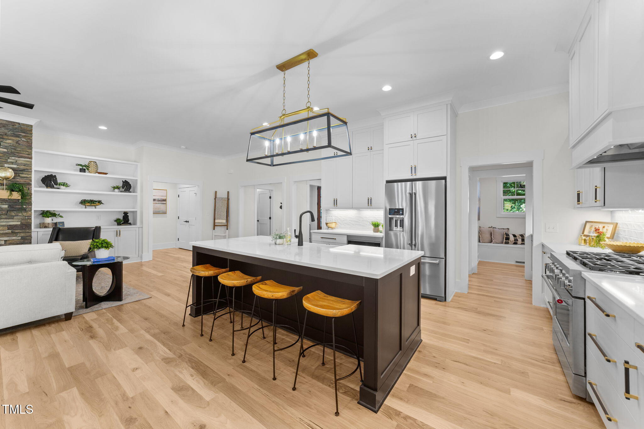 2817 Silk Hope Gum Springs Road Pittsboro, NC 27312 - Photo 15 of 56 a kitchen with stainless steel appliances a table chairs and a refrigerator