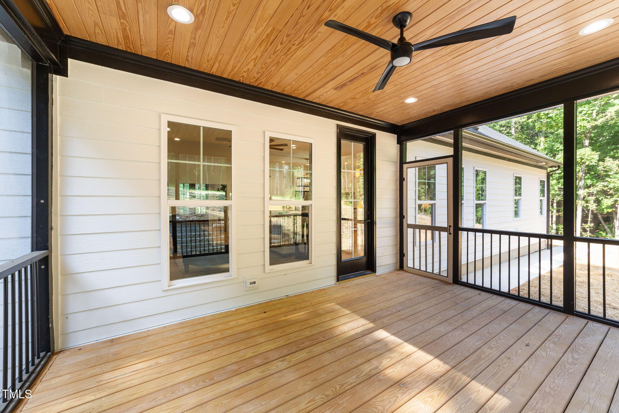 2817 Silk Hope Gum Springs Road Pittsboro, NC 27312 - Photo 41 of 56 a view of a porch with wooden floor and floor to ceiling window
