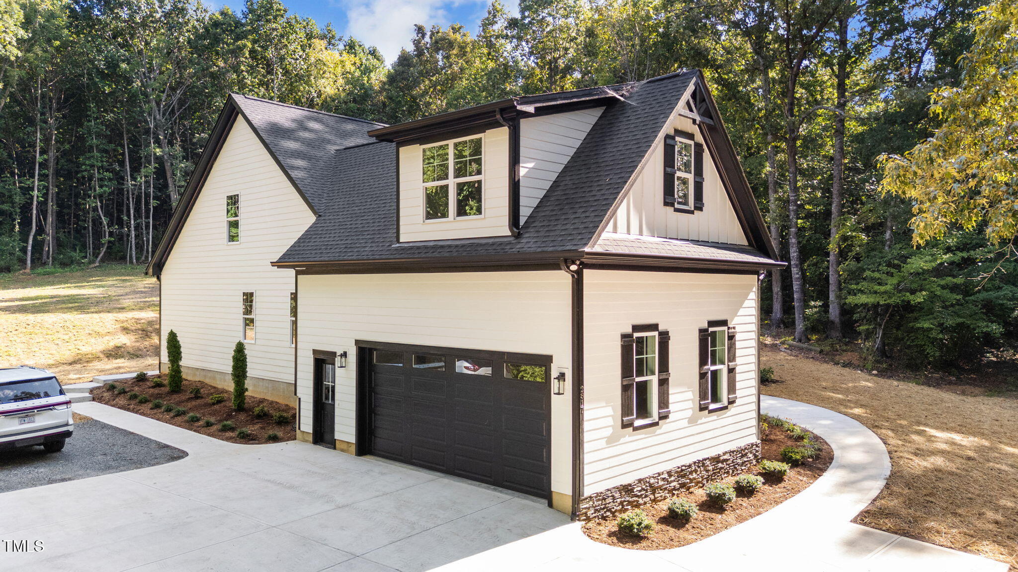 2817 Silk Hope Gum Springs Road Pittsboro, NC 27312 - Photo 44 of 56 a view of a white house with many windows and yard