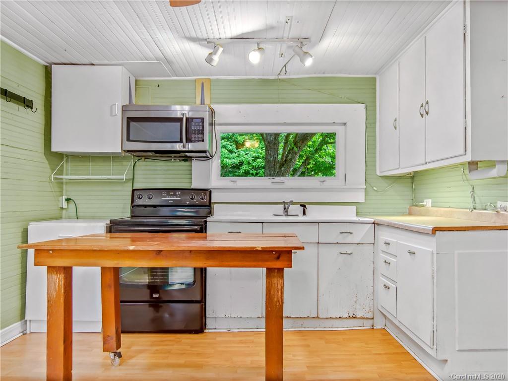 5020 Dutch Cove Road Canton, NC 28716 - Photo 10 of 19 a kitchen with stainless steel appliances kitchen island granite countertop a stove a sink and a microwave