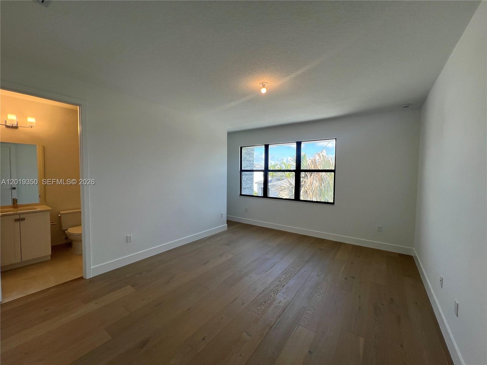 9172 Silver Marsh Lane, Unit 9172 Boca Raton, FL 33434 - Photo 14 of 34 an empty room with wooden floor and windows