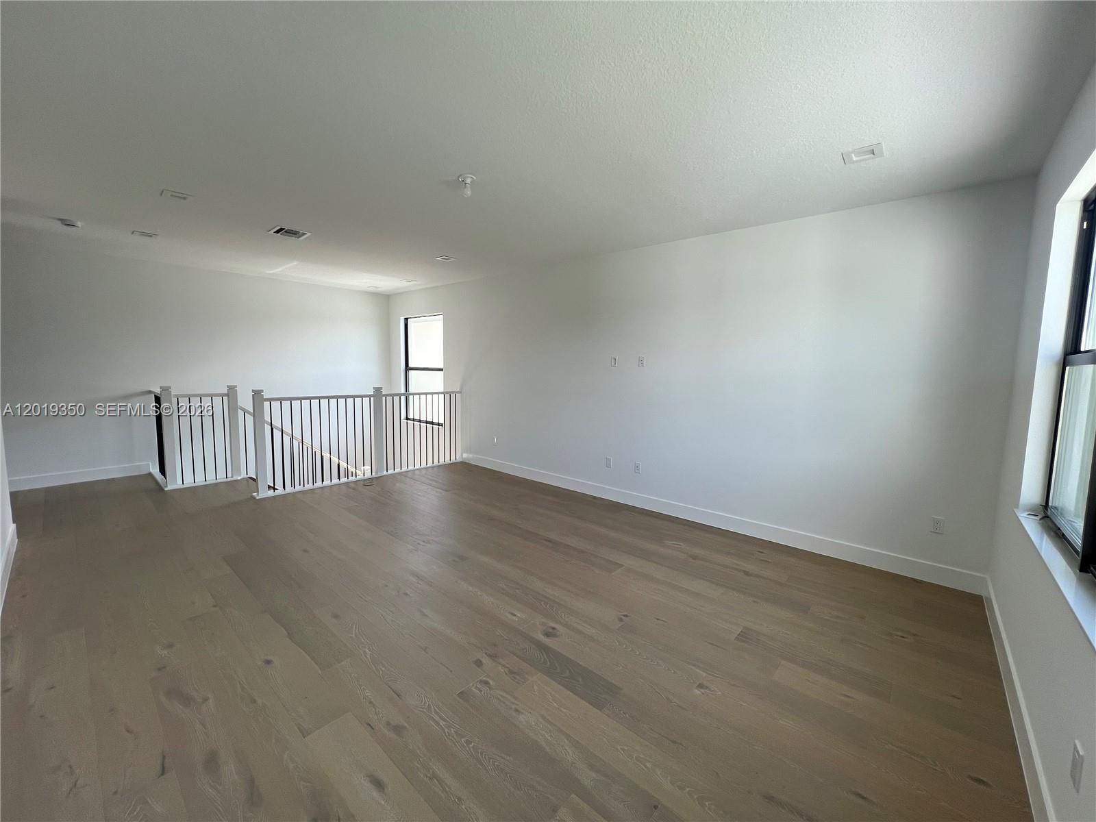 9172 Silver Marsh Lane, Unit 9172 Boca Raton, FL 33434 - Photo 19 of 34 an empty room with wooden floor and windows