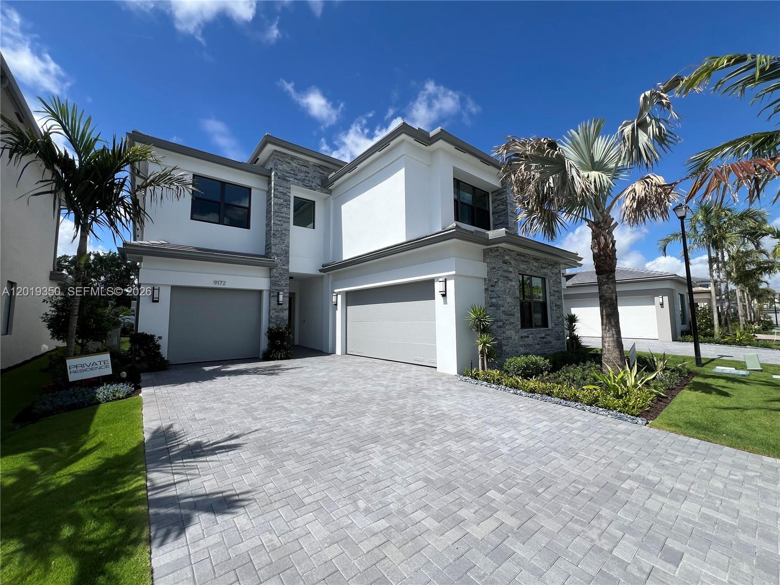 9172 Silver Marsh Lane, Unit 9172 Boca Raton, FL 33434 - Photo 2 of 34 a front view of a house with a yard and garage