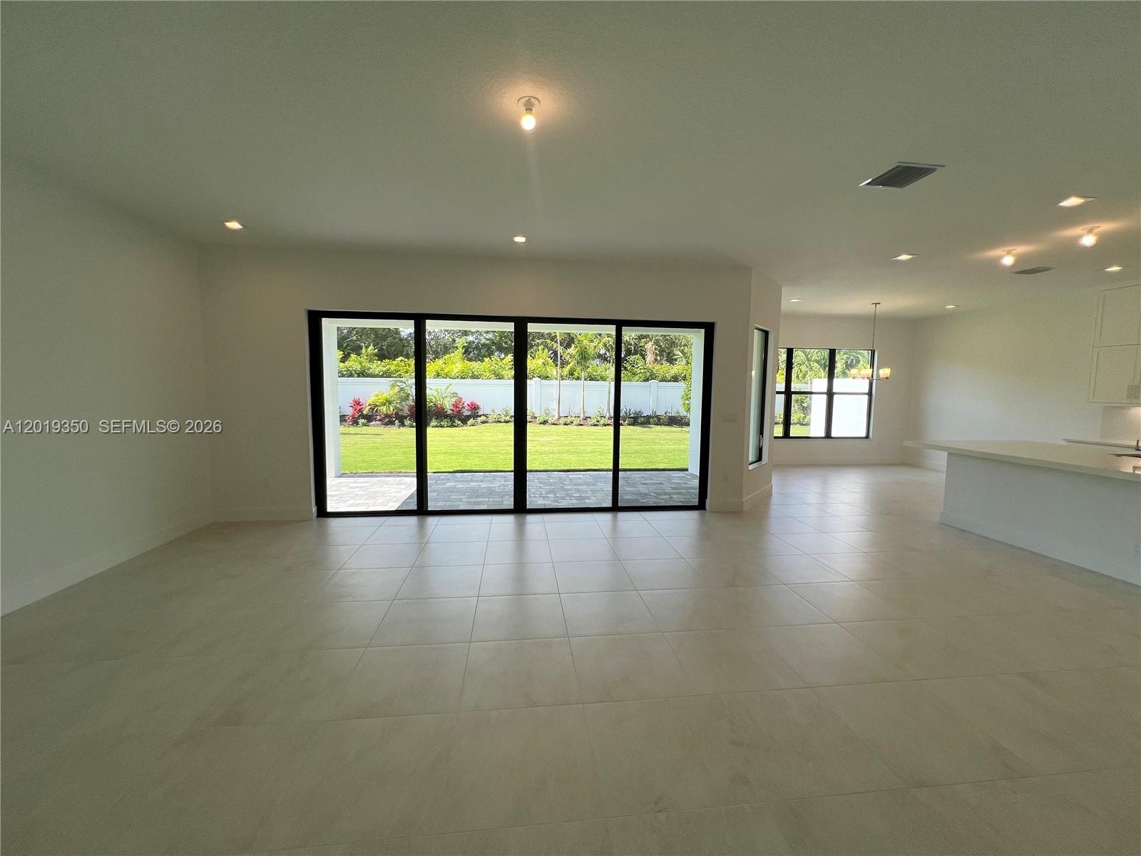 9172 Silver Marsh Lane, Unit 9172 Boca Raton, FL 33434 - Photo 5 of 34 an empty room with wooden floor and windows