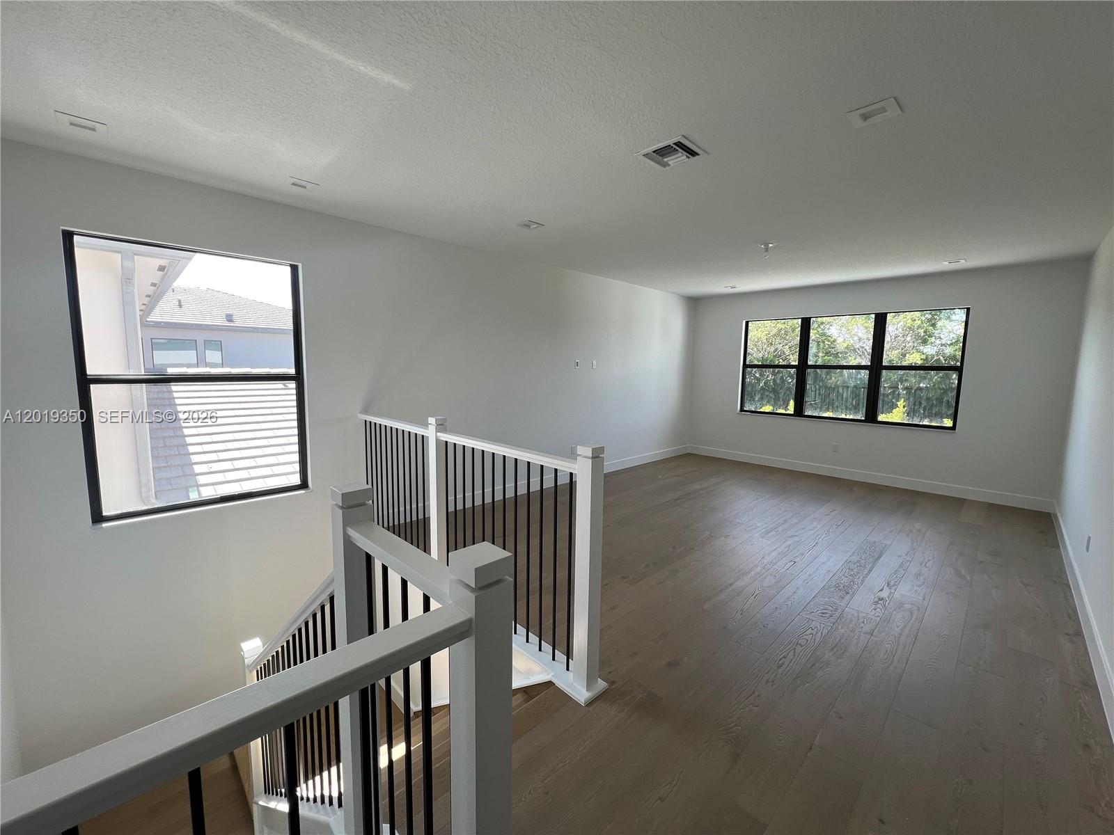 9172 Silver Marsh Lane, Unit 9172 Boca Raton, FL 33434 - Photo 10 of 34 a view of an empty room with wooden floor and a window