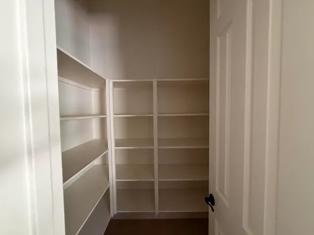 a view of walk in closet with empty racks