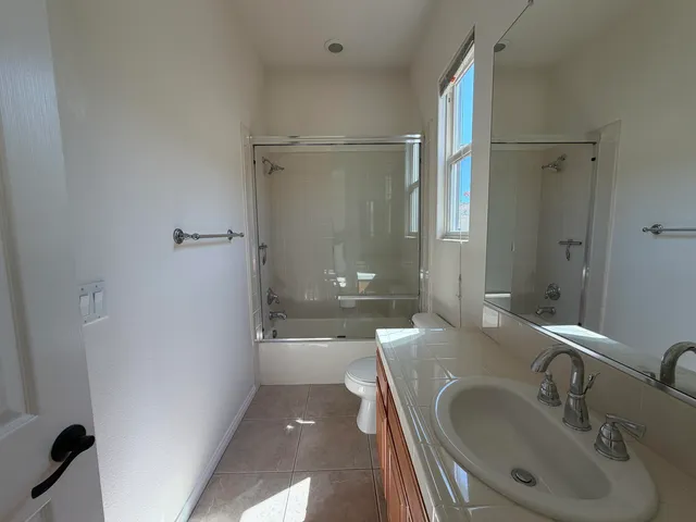 a bathroom with a sink and mirror with shower