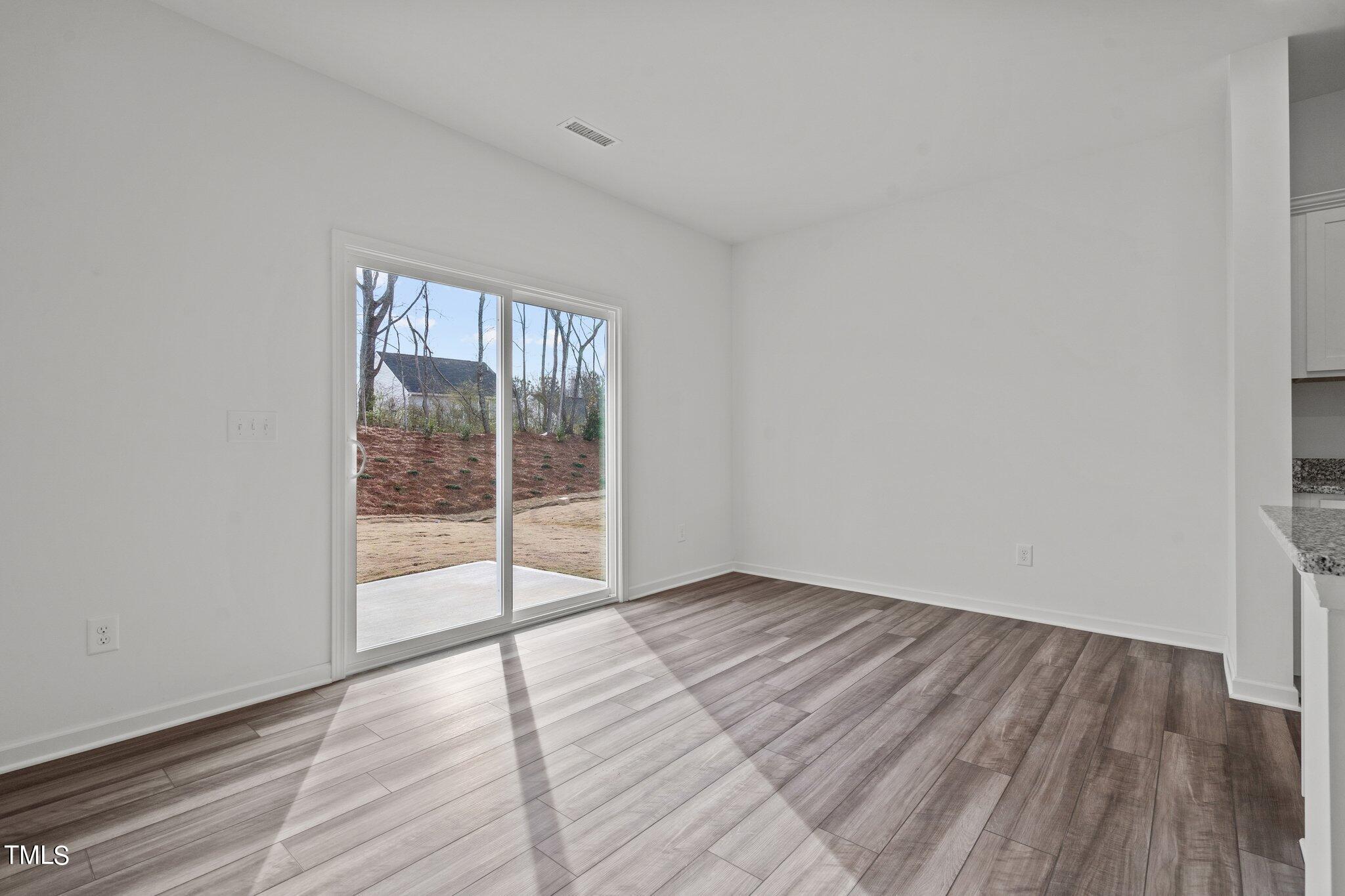 904 Rift Vly Drive Zebulon, NC 27597 - Photo 14 of 43 a view of an empty room with wooden floor and a window
