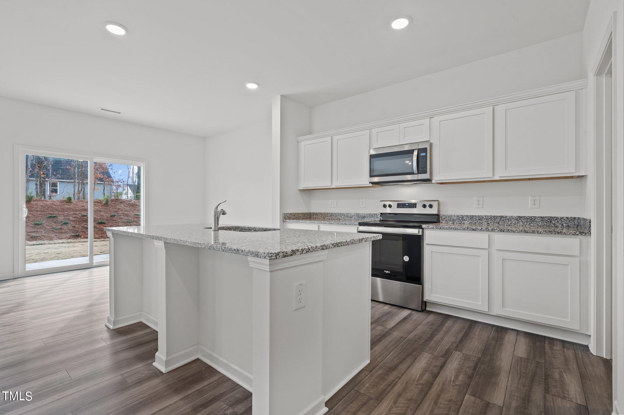 904 Rift Vly Drive Zebulon, NC 27597 - Photo 8 of 43 a kitchen with granite countertop white cabinets and white appliances