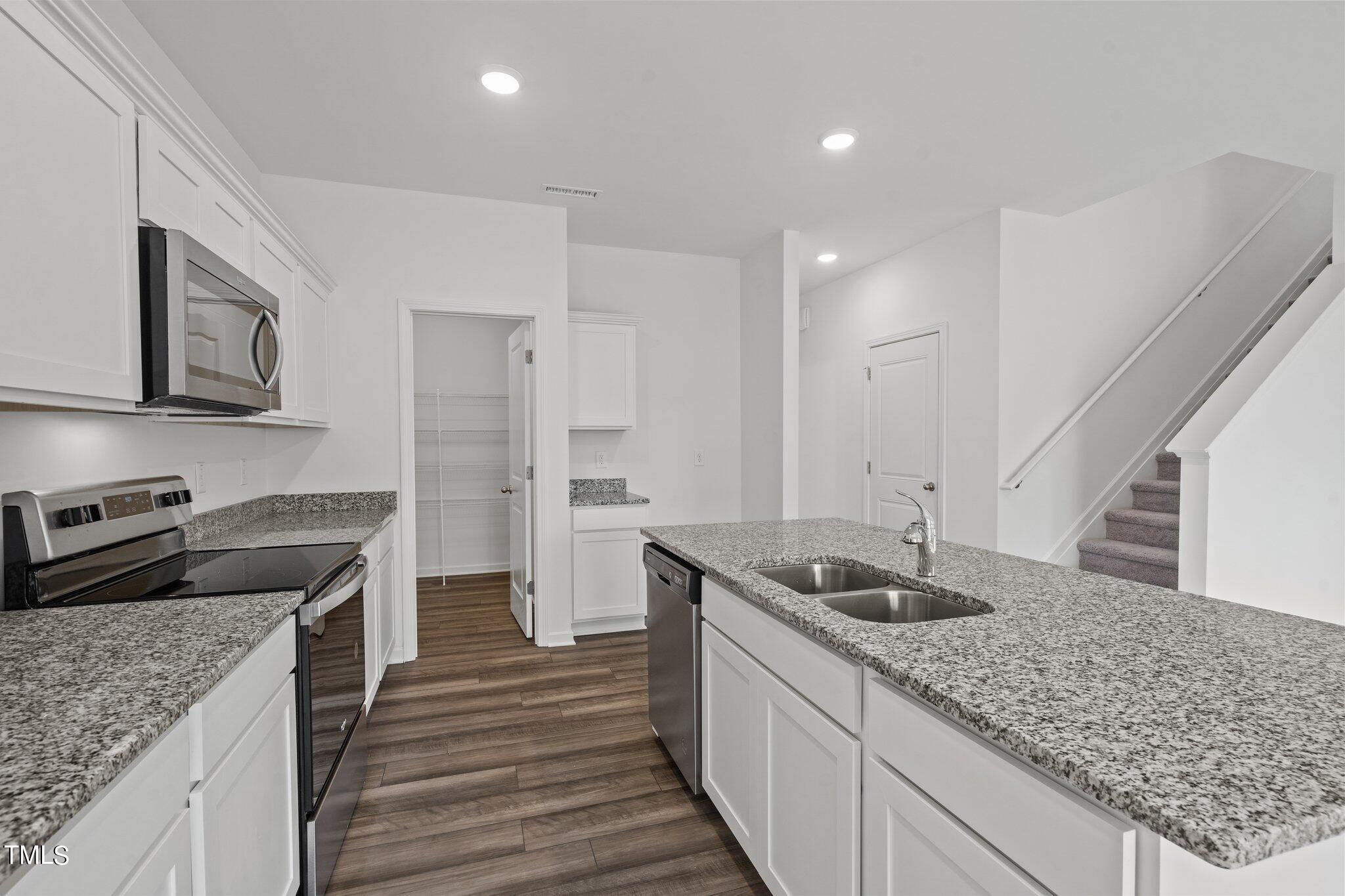 904 Rift Vly Drive Zebulon, NC 27597 - Photo 10 of 43 a kitchen with stainless steel appliances granite countertop a sink stove and refrigerator